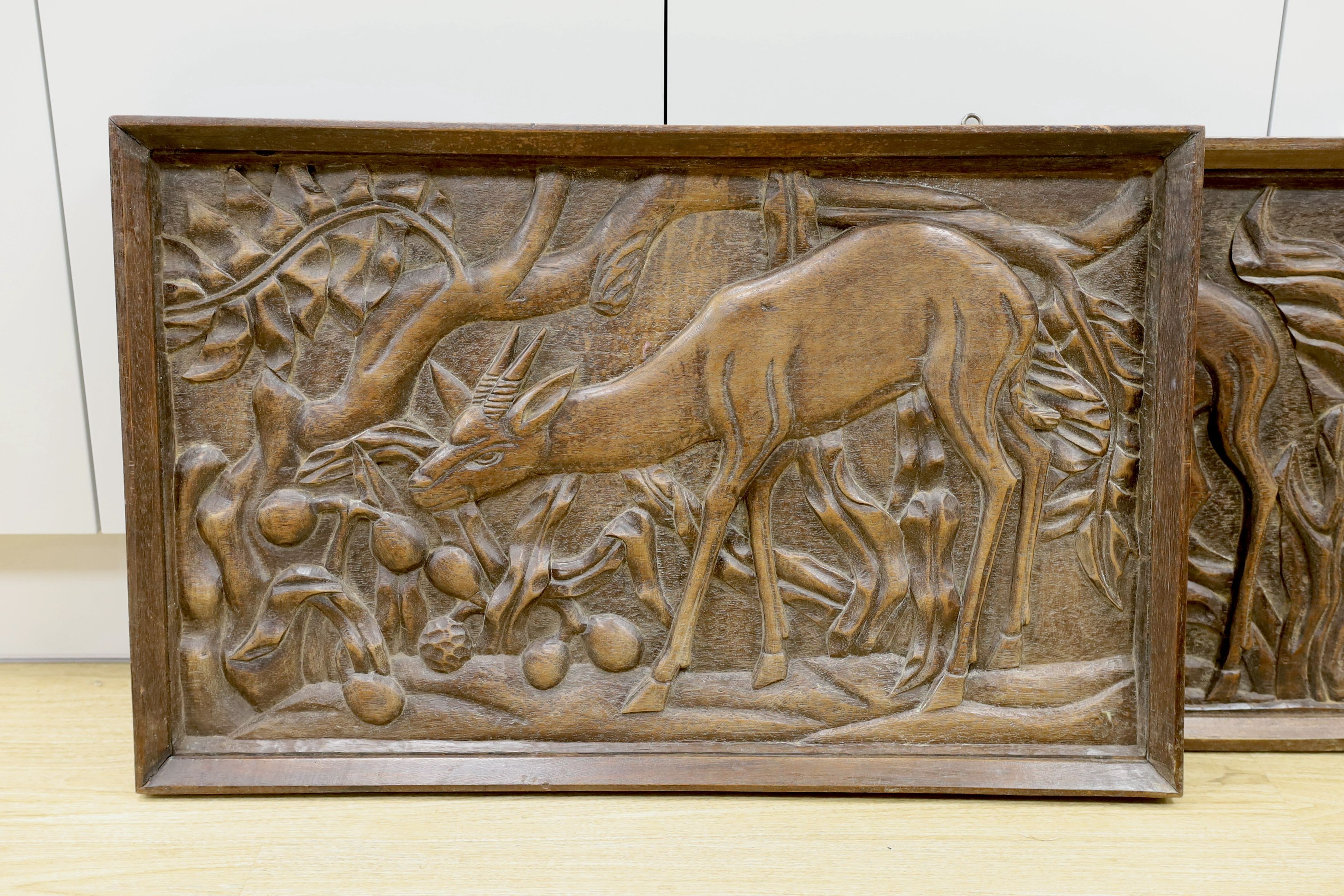 A pair of 1930's carved oak panels of deer grazing, 84 cms wide x 52 cms high.